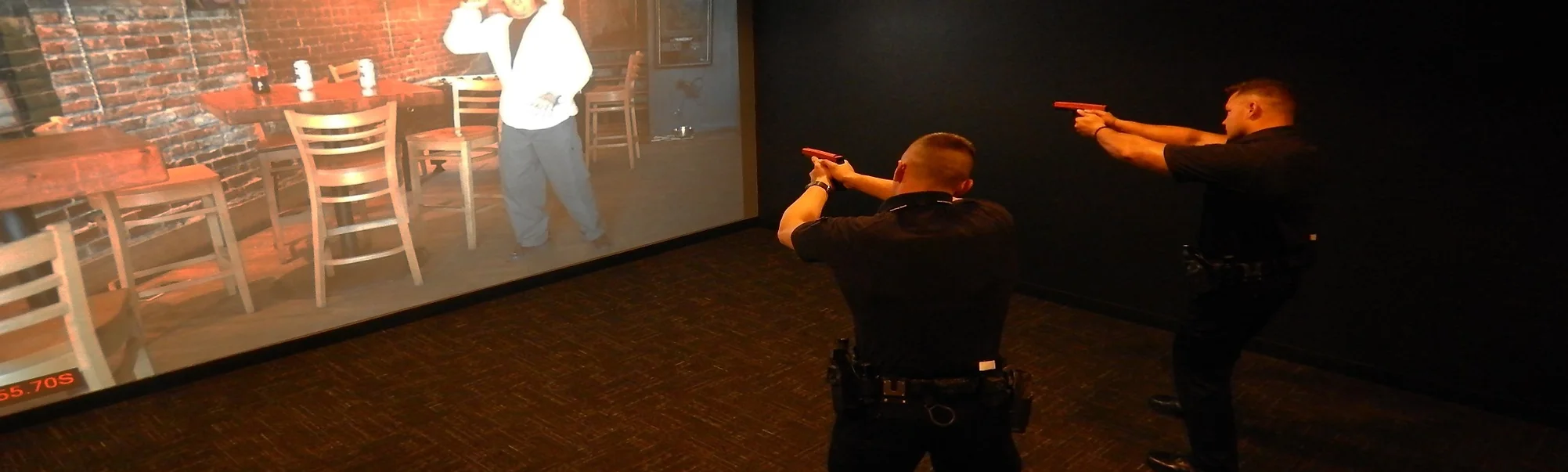 Police officers pointing guns to a wall