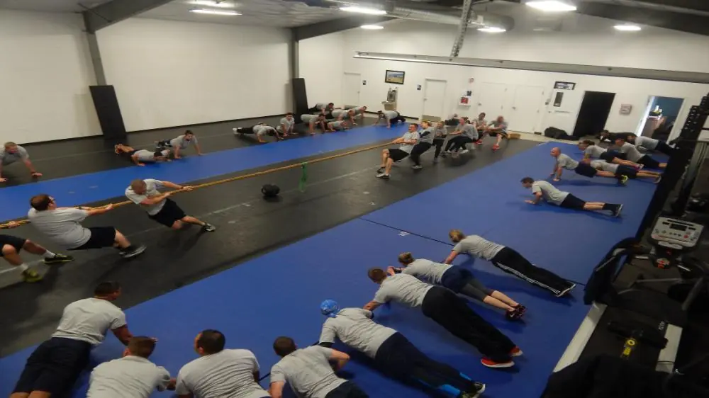 Large indoor gym with people practicing defense tactics and teamwork exercises