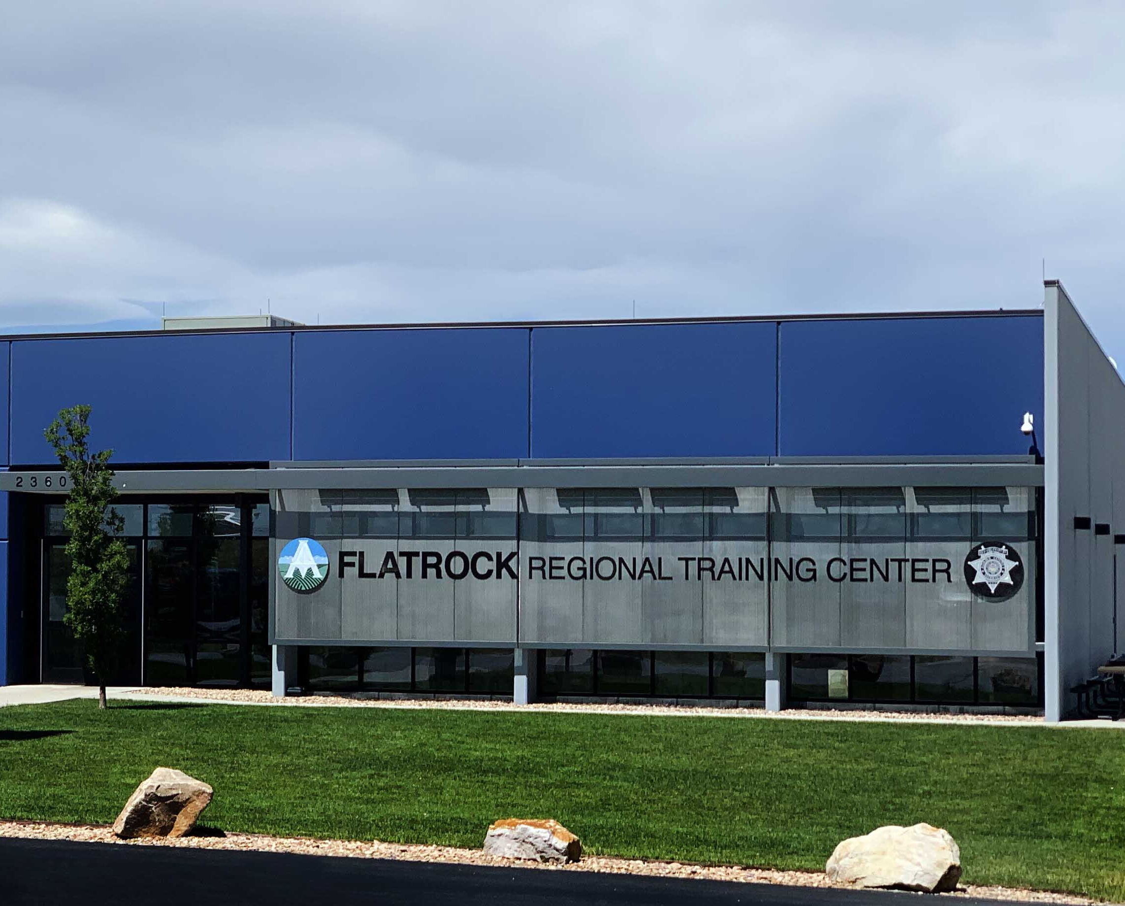 Flatrock Regional Training Center building with flags and trees, clear sky