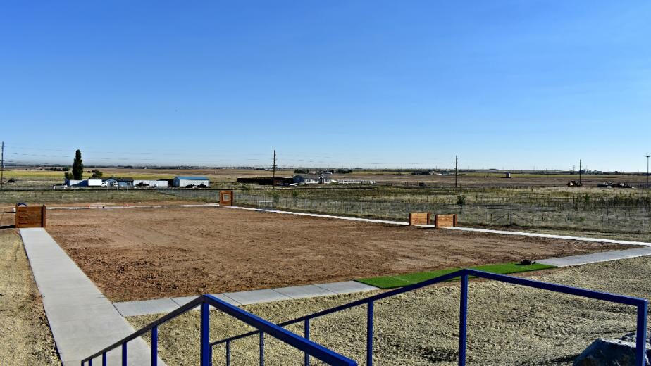 Expansive empty dirt lot with concrete borders, set in rural landscape.