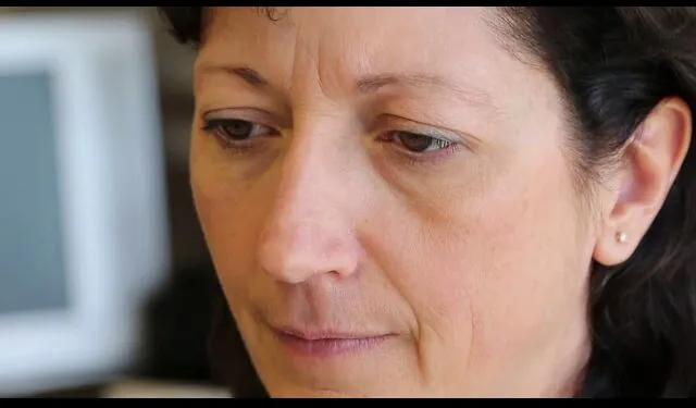Focused woman with a thoughtful expression indoors.