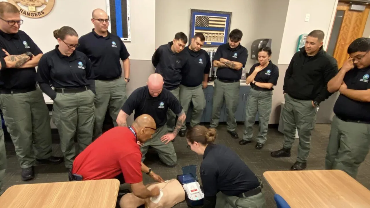 Training session on CPR techniques by uniformed officers, Colorado Rangers patch visible