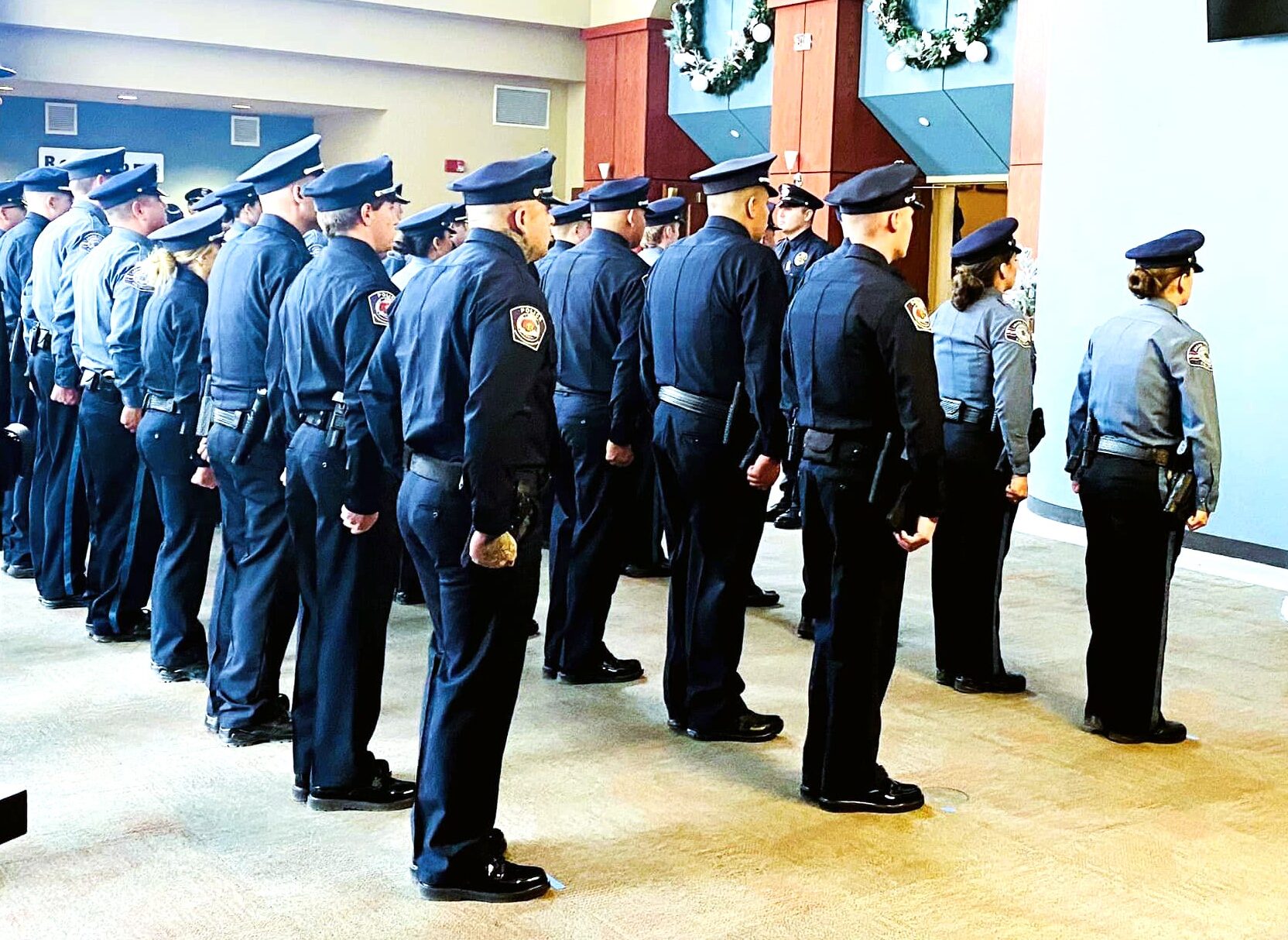 Graduation-Picture-Website-Edit.jpg, a group of uniformed officers standing in formation indoors