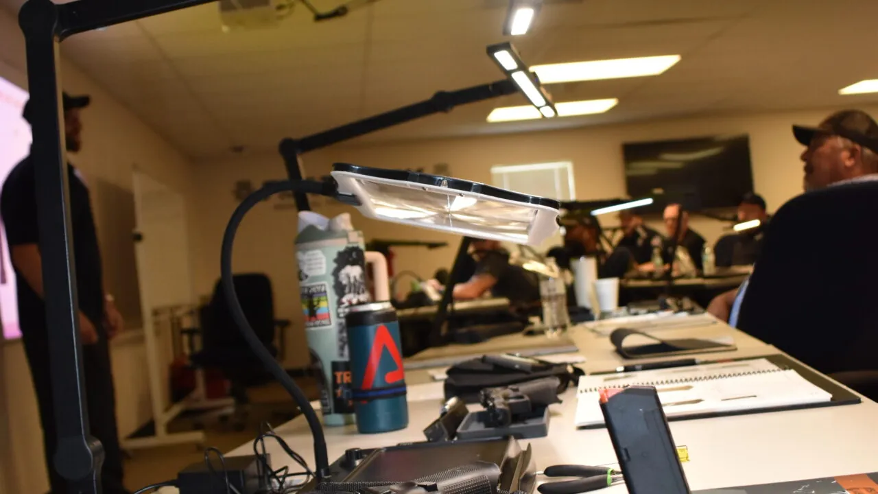 Training session with tools and notes on a desk, people listening attentively